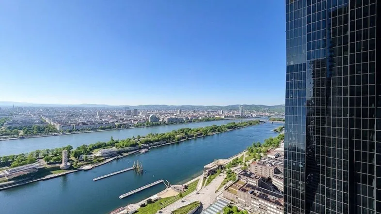 Panoramablick auf die Donau und die Wiener Skyline von einem modernen Hochhaus.