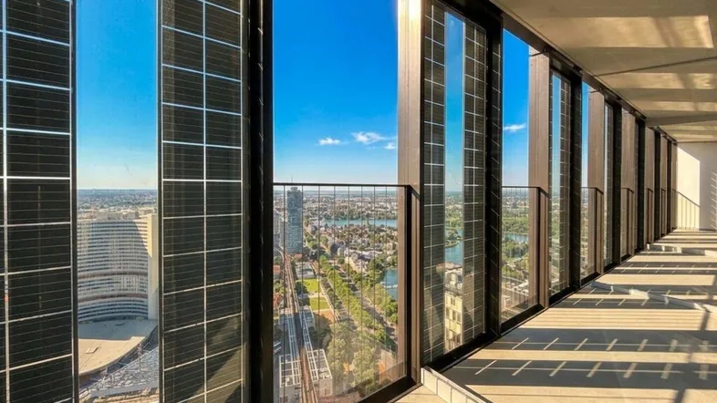 Helle Loggia mit beeindruckendem Stadtblick und modernen Glasfronten.