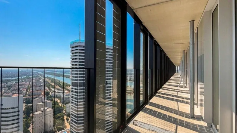 Langer Balkon in großer Höhe mit Panoramablick auf die Stadt und den Fluss.
