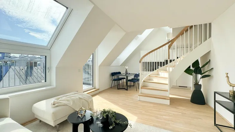 Helles Wohnzimmer mit moderner Wendeltreppe, großen Fenstern und hellem Parkettboden.