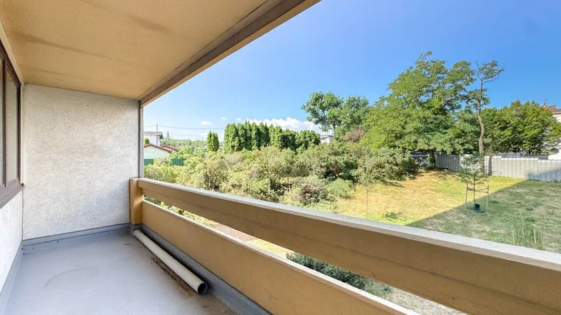Geräumiger Balkon mit Blick ins Grüne und viel Tageslicht, ideal zum Entspannen.