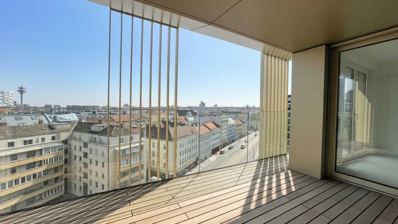 Geräumiger Balkon mit Holzboden und weitem Blick über die Stadt bei Sonnenschein.