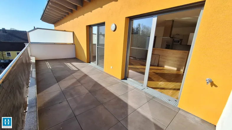 Geräumige Terrasse mit Fliesenboden und Zugang zu den Innenräumen, ideal für Entspannung im Freien.