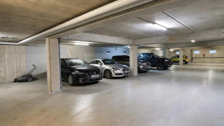 Geräumige Tiefgarage mit Betonwänden und -decken, ausreichend Platz für mehrere Fahrzeuge.