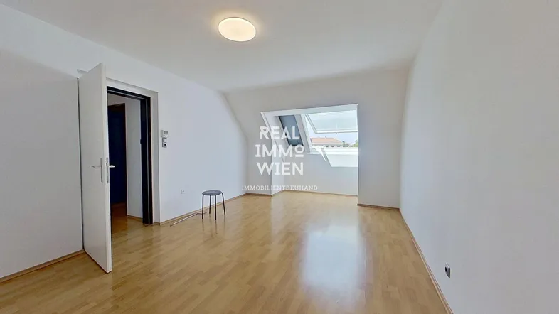 Helles Zimmer mit Dachschrägen, Parkettboden und Dachfenstern, ideal für flexible Nutzung.