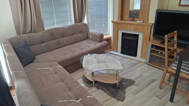Gemütliches Wohnzimmer mit großem Ecksofa, Couchtisch und dekorativem Kaminbereich.