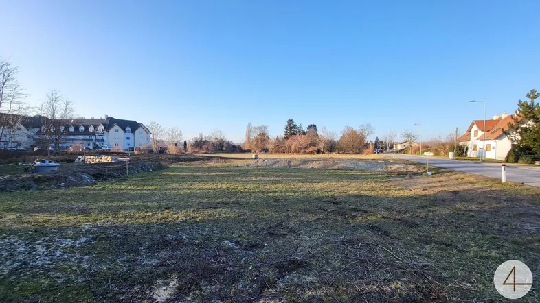 Weitläufiges Grundstück mit freiem Blick auf die Umgebung und angrenzende Bebauung unter blauem Himmel.