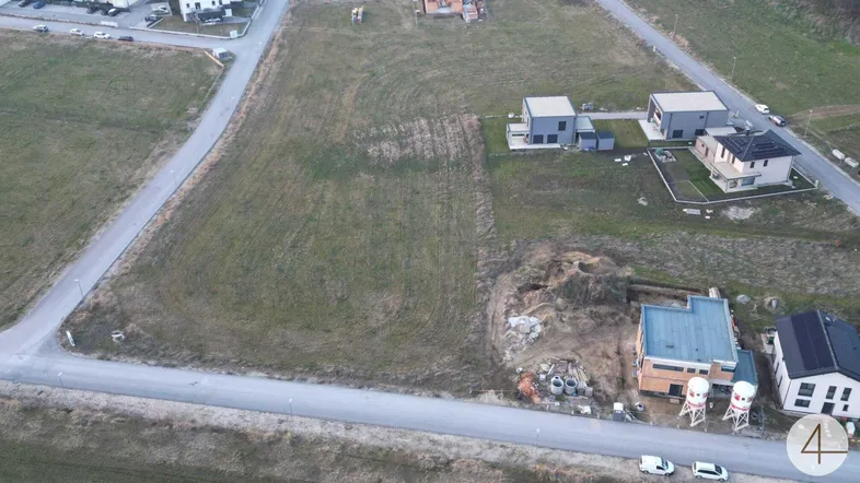 Luftaufnahme eines Baugrundstücks in ländlicher Umgebung mit umliegenden Häusern und Straßen.