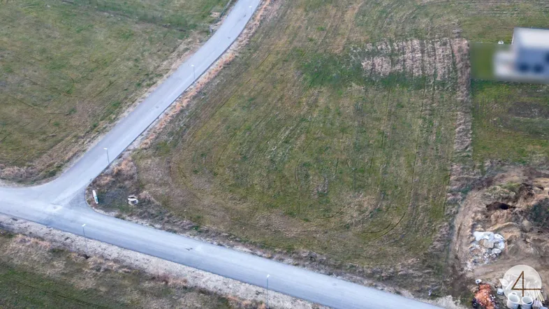Luftaufnahme eines Baugrundstücks mit umliegenden Straßen und Grünflächen, ideal für zukünftige Bauprojekte.