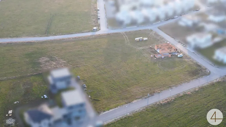 Luftaufnahme eines Baugrundstücks mit beginnender Bebauung in ländlicher Umgebung.