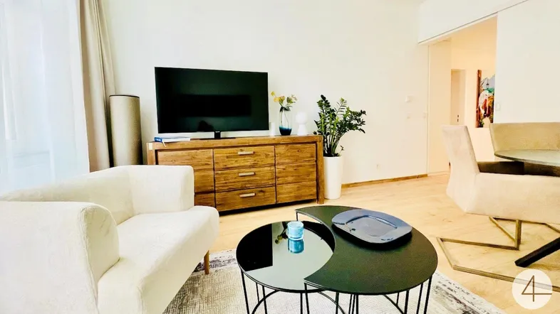 Helles Wohnzimmer mit modernem Holzschrank, beigem Sofa und stilvollem Couchtisch.