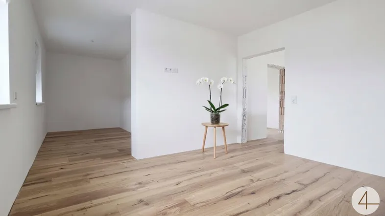 Heller Raum im Neubau mit neu verlegtem Holzfußboden und minimalistischer Dekoration.
