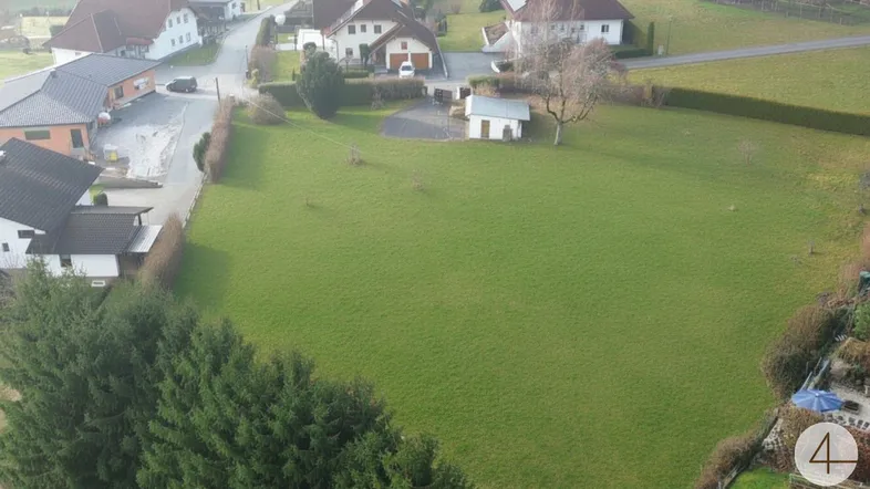 Großes, unbebautes Grundstück aus der Vogelperspektive, umgeben von Natur und Wohnbebauung.