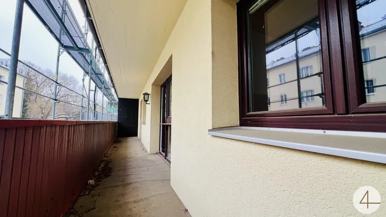 Langer Balkon mit Gerüst an der Fassade, bietet einen Blick auf die umliegenden Gebäude.