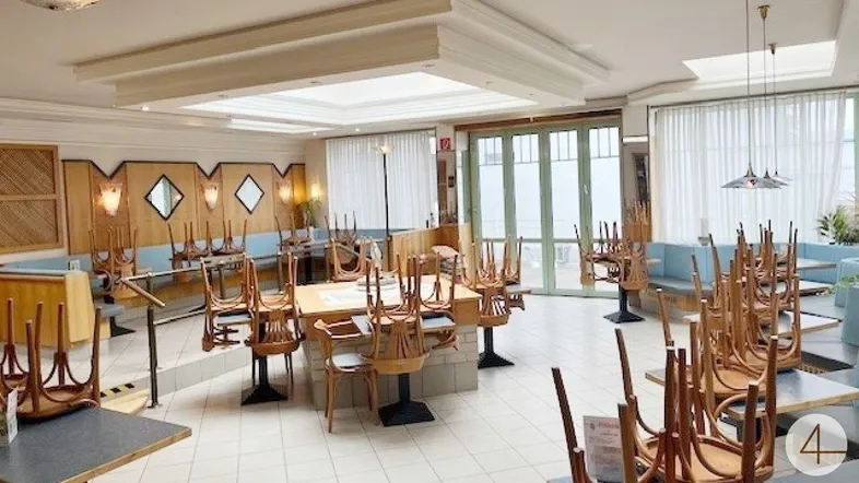 Geräumiger Restaurant-Essbereich mit vielen Tischen und Stühlen, bereit für Gäste und mit Oberlichtern.