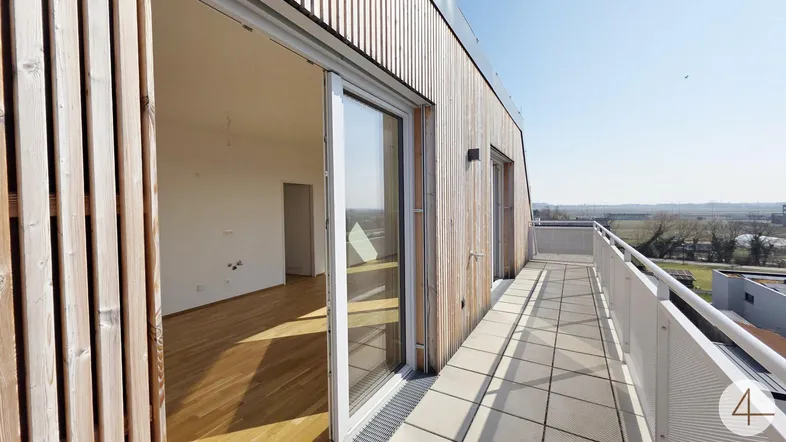 Geräumige Terrasse mit Holzelementen und weitem Blick über die Landschaft.