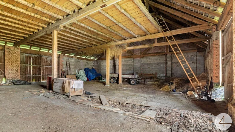 Geräumiger Innenbereich einer Scheune mit Holzbalken und viel Stauraum.