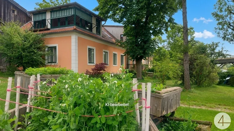 Charmantes Landhaus mit oranger Fassade, grünen Fensterläden und einem gepflegten Gartenbereich mit Hochbeet.