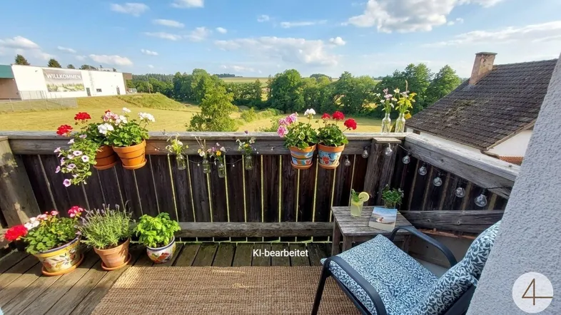 Gemütlicher Balkon mit vielen Pflanzen, Sitzgelegenheiten und weitem Blick in die grüne Landschaft.