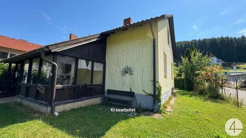 Seitenansicht des Hauses mit einem Wintergarten und einem gepflegten Rasenbereich unter blauem Himmel.