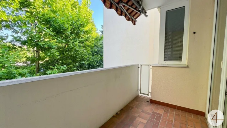 Kleiner Balkon mit Terrakottafliesen und Blick ins Grüne, ideal für entspannte Stunden im Freien.
