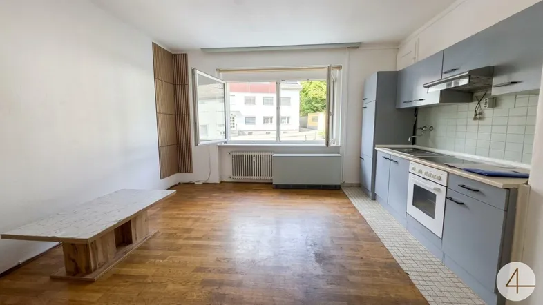 Heller offener Wohn- und Essbereich mit integrierter Küche und Blick nach draußen.