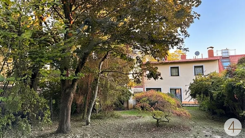 Großer Gartenbereich mit altem Baumbestand und Blick auf die Rückseite des Hauses.