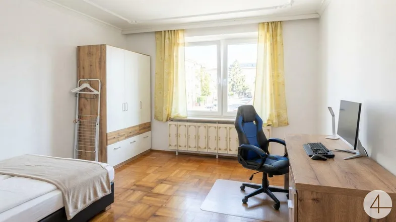 Helles Schlafzimmer mit Parkettboden, Schreibtisch und Kleiderschrank, ideal für Studenten oder Home-Office.