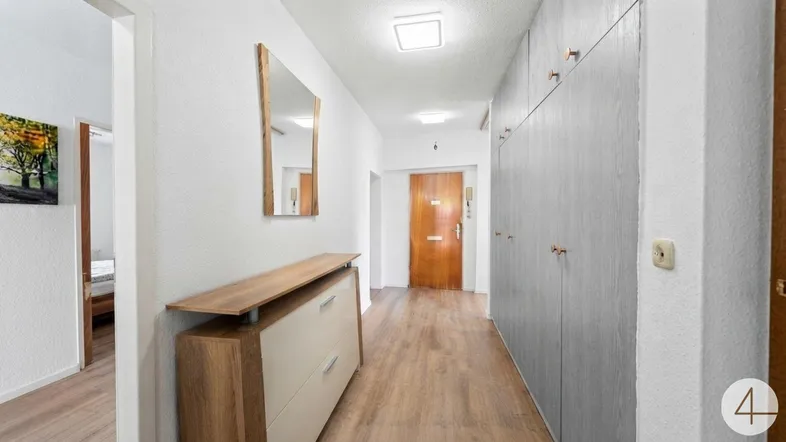 Heller Flur mit praktischen Einbauschränken, Holzfußboden und einem modernen Schuhschrank.