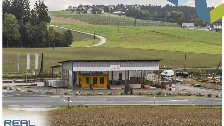 Weitläufige Außenansicht eines Gewerbegebäudes mit umliegenden Feldern und ländlicher Umgebung.
