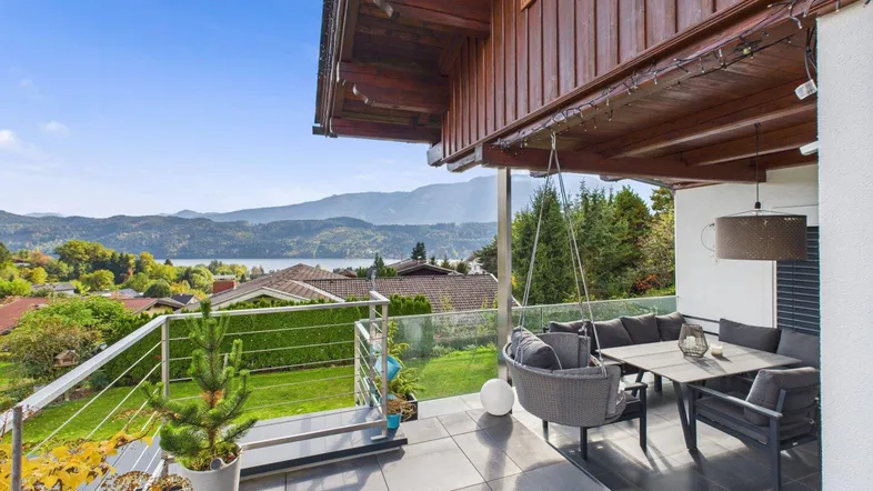 Überdachte Terrasse mit Sitzbereich und atemberaubendem Blick auf den See und die umliegende Landschaft.