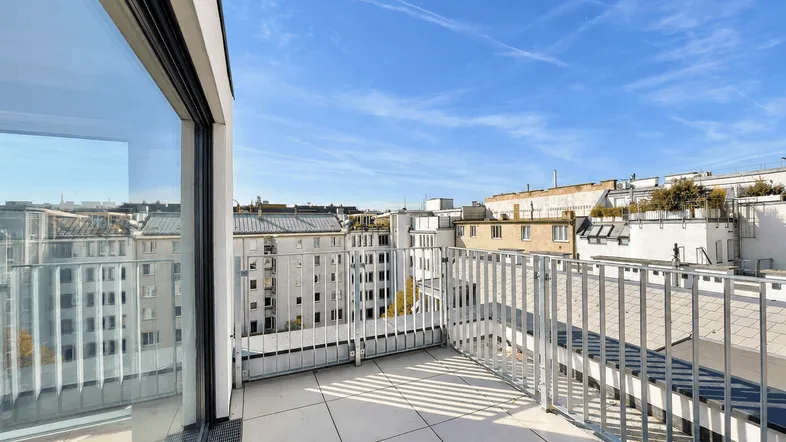 Geräumige Dachterrasse mit modernem Geländer und weitem Blick über die Stadt.