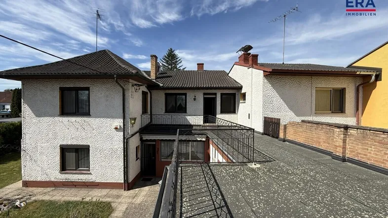 Rückansicht des Hauses mit Flachdachbereich und einer Außentreppe.