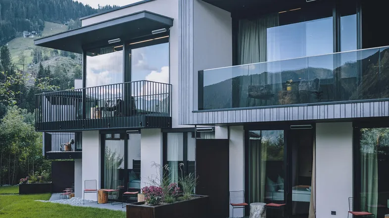 Moderne Architektur mit Balkonen, Terrassen und Bergblick in alpiner Umgebung.