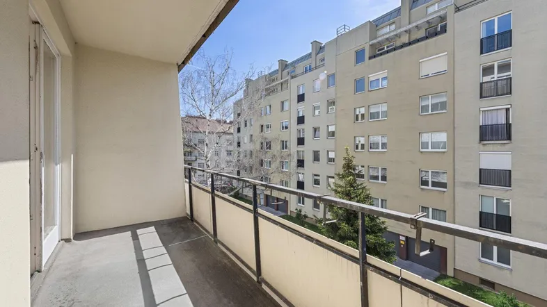 Geräumiger Balkon mit Blick auf die umliegenden Gebäude und viel Tageslicht.