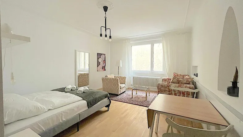 Helles Studio-Apartment mit Schlafbereich, Essplatz und gemütlichen Sesseln.