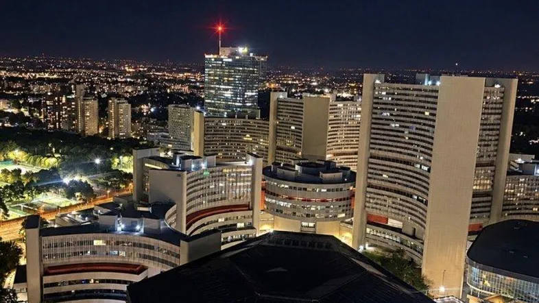 Nachtaufnahme der Stadt mit beleuchteten Hochhäusern und weitreichendem Blick über die urbane Landschaft.