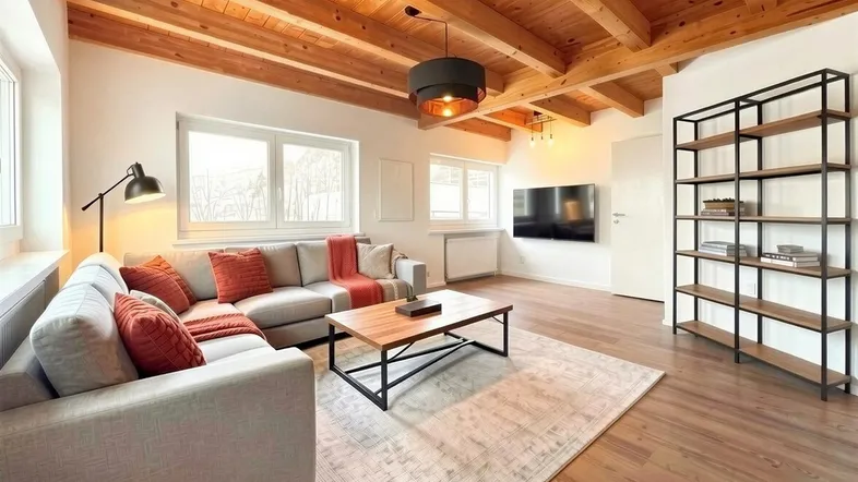 Helles Wohnzimmer mit Holzbalkendecke, modernem Sofa und Holzboden.