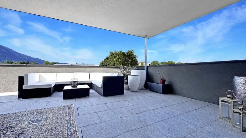 Geräumige Dachterrasse mit moderner Lounge-Möblierung und weitem Blick auf die umliegende Landschaft.