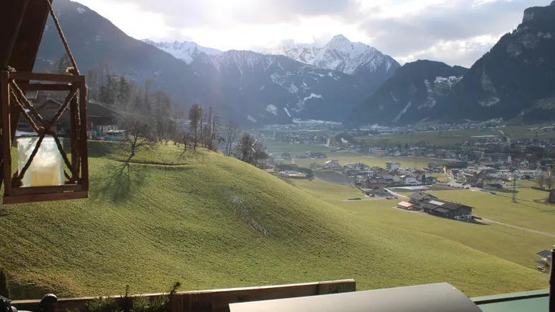 Sonniger Balkon mit atemberaubendem Blick auf die schneebedeckten Berge und das Tal.