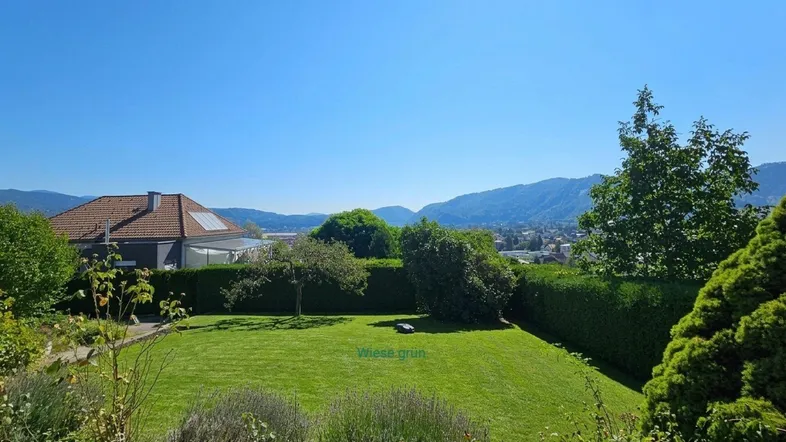 Großer, gepflegter Garten mit weitem Blick auf die umliegende Landschaft und Berge.