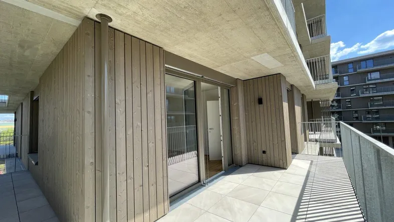 Geräumige Terrasse mit Fliesenboden und Holzverkleidung, ideal für entspannte Stunden im Freien.