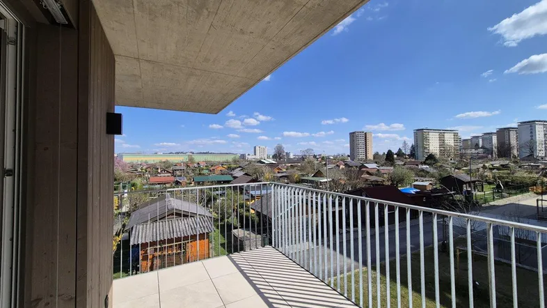 Geräumiger Balkon mit Fliesenboden und weitem Blick über die Umgebung und die Stadt.