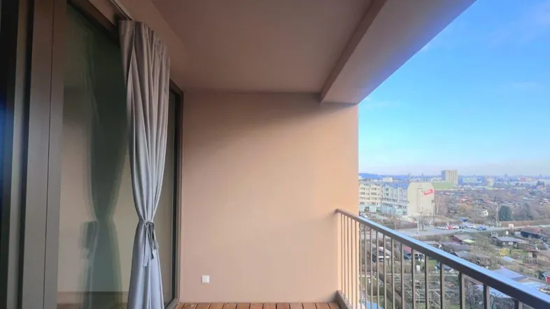 Heller Balkon mit Holzboden und weitem Blick über die Stadtlandschaft.