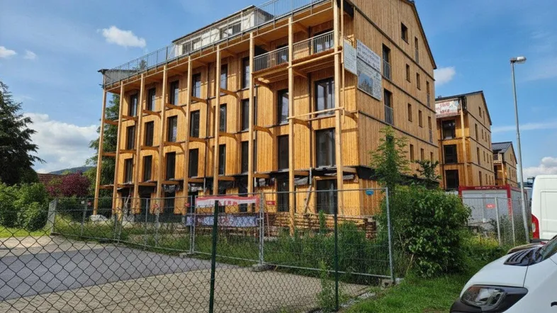 Neubau eines Mehrfamilienhauses in Holzbauweise mit mehreren Etagen und Balkonen.