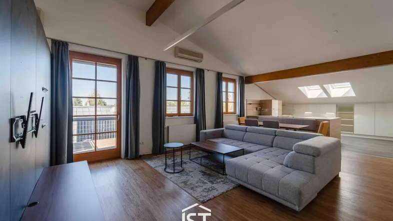 Helles Wohnzimmer mit Holzbalken, Parkettboden und Zugang zu einem französischen Balkon.