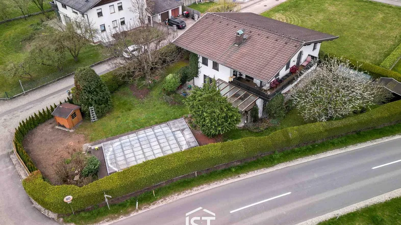 Luftaufnahme des Anwesens mit Wohnhaus, Garten, Pool und umliegender Landschaft.
