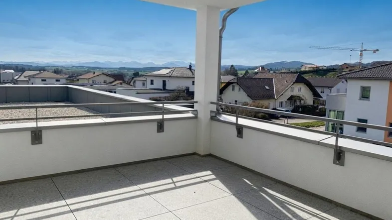 Geräumiger Balkon mit Fliesenboden und weitem Blick über die Landschaft und Berge.