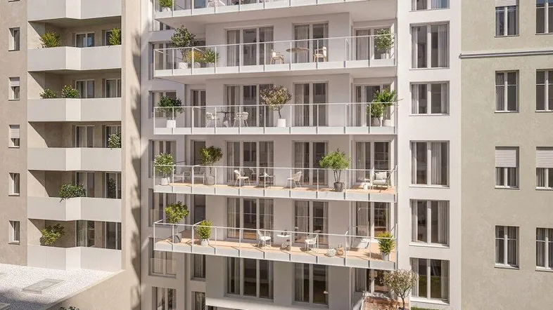 Moderne Wohnanlage mit mehreren Balkonen, Dachterrassen und einem kleinen Gemeinschaftsgarten im Erdgeschoss.