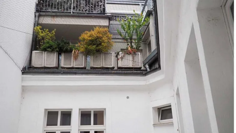 Blick auf begrünte Balkone und Terrassen von einem Innenhof aus.